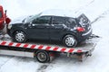 Evacuation of a broken car in cold winter. In winter, a tow truck takes the car away after an accident. Car assistance in winter Royalty Free Stock Photo