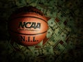 Eveleth, MN - USA - 03-08-2022: An NCAA Final Four basketball with NIL text surrounded by money Royalty Free Stock Photo