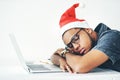 Even Santa needs to take a break. a young businessman sleeping on his desk while working in his office on Royalty Free Stock Photo