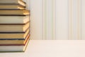 A neat stack of books on the edge of the white table Royalty Free Stock Photo