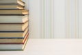 A neat stack of books on the edge of the white table Royalty Free Stock Photo