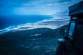 Evening blue tones landscape with black off road car parked with mountains and coast view - wild ocean and landscape concept for Royalty Free Stock Photo