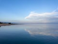 Evening calm and smooth lake surface under soft clouds Royalty Free Stock Photo