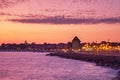 Evening city landscape - view of the embankment with street lights and the wooden windmill before the entering to the Old Town of Royalty Free Stock Photo