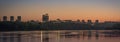 Evening city by the river - panorama. Orange sunrise or sunset over the city.