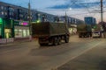 Evening in the city, on the road. It`s dark, the military transport returns to the base after the mission.