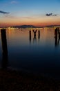 Evening city, the sea is beautifully reflected city lights. Mountains and sunset in the background.