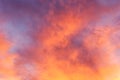 Orange yellow purplish clouds in bluish sky by sunset