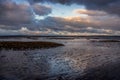 Evening clouds reflect on mud and water in the Skern area of Northam Burrows, near Appledore, North Devon. Royalty Free Stock Photo