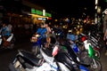 Evening crowded and busy Thai street along which parked mopeds
