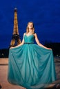Evening Eiffel tower with lights in the background. Portrait of a gorgeous romantic young sensual girl in a fashionable dress