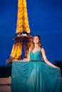 Evening Eiffel tower with lights in the background. Portrait of a gorgeous romantic young sensual girl in a fashionable dress