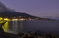 Evening Embankment of Yalta on the Black Sea coast on the background of mountains and sunset sky with clouds Royalty Free Stock Photo