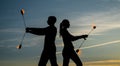 Evening with fire performance. Couple of fire dancers on evening sky. Sexy woman and man spin burning poi in dusk. Night Royalty Free Stock Photo