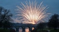 Evening Fireworks Display Above Stone Bridge and Reflecting River, Festive Celebration Royalty Free Stock Photo