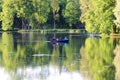 Evening Gatchina Park is lit by the summer sun.Family swims on a boat on the lake.