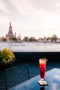 Evening glass of red berry cocktail with Wat Arun pagoda and Chao Praya river view, Bangkok Royalty Free Stock Photo