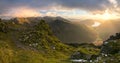 Evening golden sunlight shining across Lake District fells from great gable summit