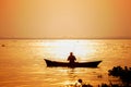 Evening golden sunset time, a fisherman fishing on the seaside on a boat Royalty Free Stock Photo