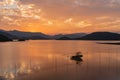 The evening lake reflected the sunset glow and mountains