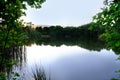 evening landscape with forest lake, river, line of trees is reflected in water, blue sky is reflected in calm water surface, Royalty Free Stock Photo