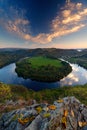 Evening landscape with river. Big Czech horse shoe meander, green vegetation with evening sun. River Vltava with white clouds. Eve