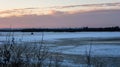 Evening landscape by the river in winter begins to melt the ice, over the horizon you can see the city