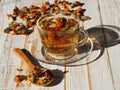 Evening light with long shadows falls on a cup of herbal medicinal tea with dried flowers of marigold Royalty Free Stock Photo