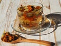 Evening light with long shadows falls on a cup of herbal medicinal tea with dried flowers of marigold Royalty Free Stock Photo