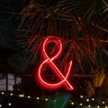 Evening lighting in the form of a luminous neon red ampersand sign