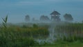 Evening mist over the Podlasie field with observation tower and a stork. Pentowo, Poland. Royalty Free Stock Photo