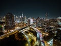 Evening in modern urban borough in metropolis. glowing high rise buildings and heavy traffic on multilane roads Royalty Free Stock Photo