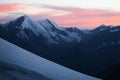 Red sky in cold mountains: sunset, snow, and rocks