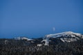 Evening in mountains - sun beams, on the pick, white moon rise in sky. clear snow in forest. Winter amazing time - Christmas Royalty Free Stock Photo