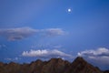 A evening, night dark blue sky with clouds with stars and the moon over the desert mountains Royalty Free Stock Photo