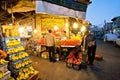 Evening outdoor market with bananas, apples and exotic fruits waiting for last customers