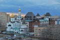 Evening panorama of the city with a view of the Volga Orthodox Institute and the Church of the Three Saints against the sunset.