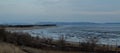 Evening panorama overlooking the frozen surface of the Volga River, sandy beach and Zhiguli mountains in the background. Royalty Free Stock Photo