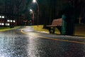 An evening park after a cold rain, lanterns illuminate the bench and the road. Royalty Free Stock Photo