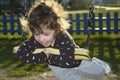 In the evening in the park on the playground girl riding on a sw Royalty Free Stock Photo