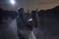 Evening photo of happy smiling dancing wedding couple. Groom and bride looking at each other and rising hands with horns Royalty Free Stock Photo