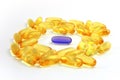 Evening Primrose Oil pills with a blue pill in the middle Royalty Free Stock Photo