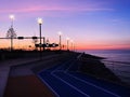 Evening promenade at pier city light people walking on horizon sunset pink sea and sky panorama Tallinn Estonia Royalty Free Stock Photo