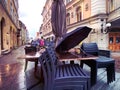 Evening  rainy city street cafe table and chair with umbrella and flowers on pavement old town of Tallinn Estonia  blurred light Royalty Free Stock Photo