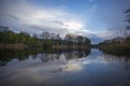 Evening river landscape, green trees, clouds and water