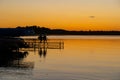 Evening scene at a Minnesota lake, with a two people on dock bench