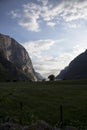 Evening shot of beautiful fjord valley, surrounded by mountains, cloudy blue skies