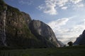 Evening shot of beautiful fjord valley, surrounded by mountains, cloudy blue skies