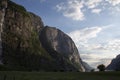 Evening shot of beautiful fjord valley, surrounded by mountains, cloudy blue skies