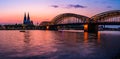 Evening silhouette skyline landscape of the gothic Cologne Cathedra, Hohenzollern railway and pedestrian bridge, the old town and Royalty Free Stock Photo